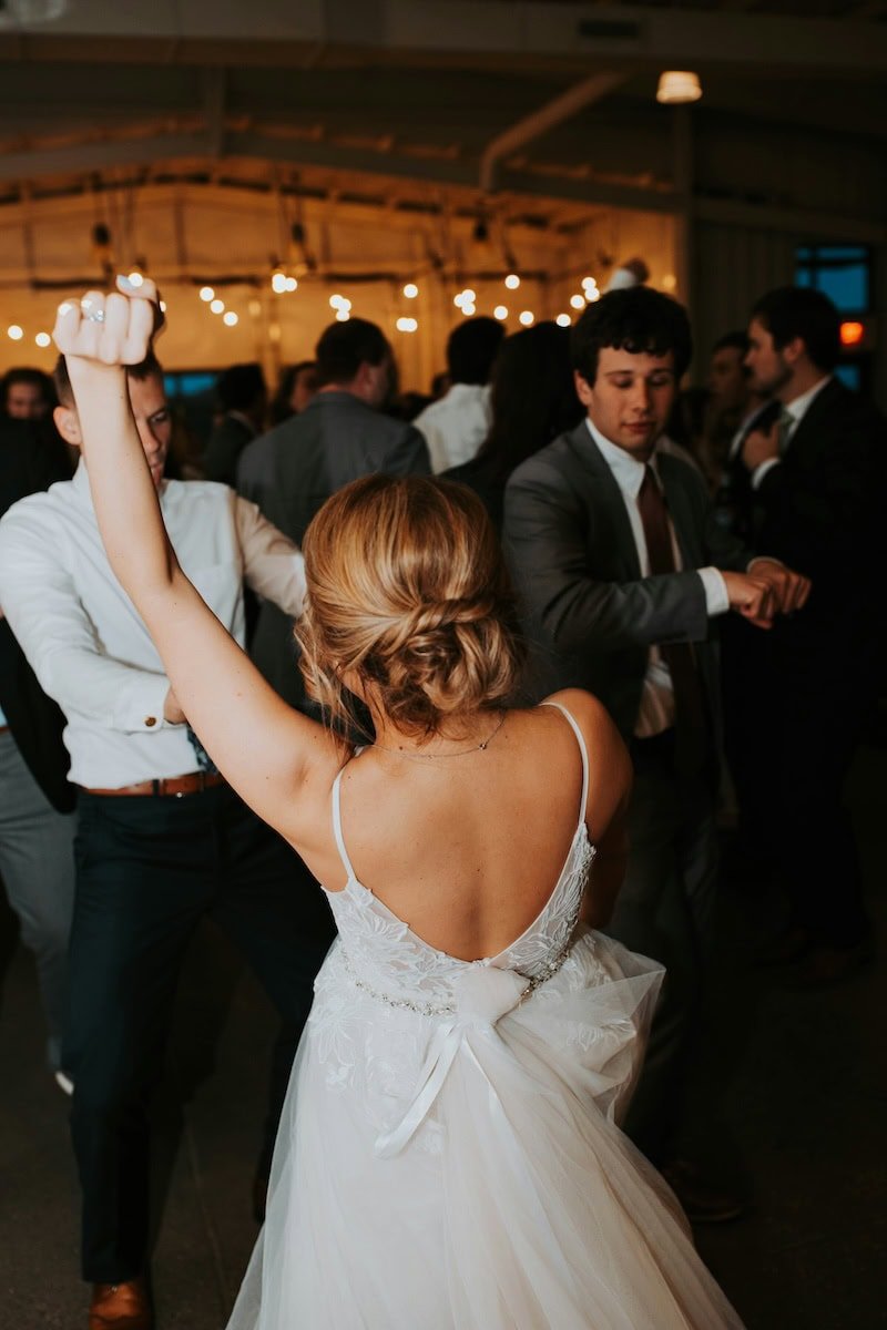 A bride dancing with her friends at a wedding reception.